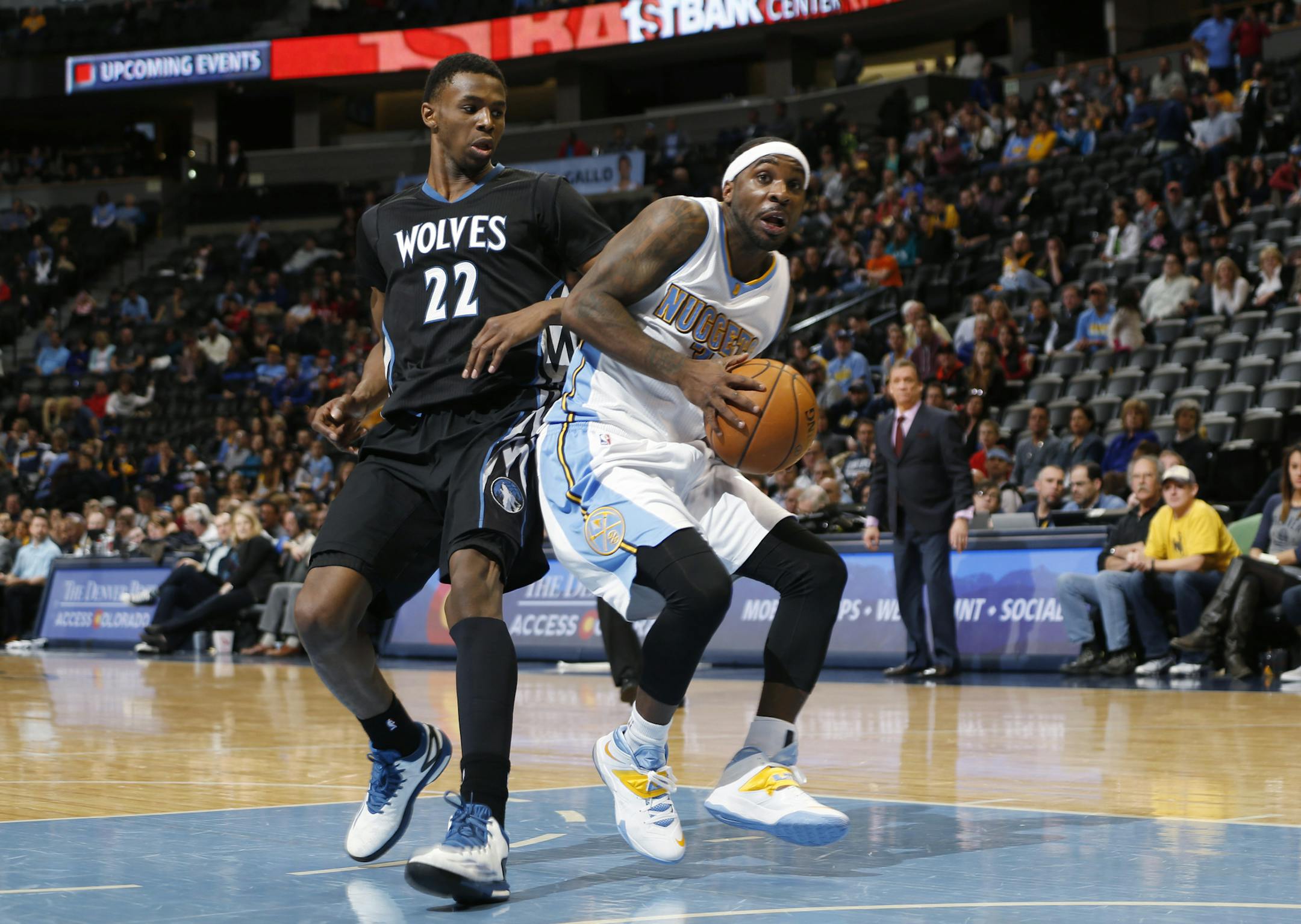Denver Nuggets guard Ty Lawson, right, is fouled by Minnesota Timberwolves guard Andrew Wiggins while driving the lane for a shot late in the fourth quarter of an NBA basketball game Saturday, Jan. 17, 2015, in Denver. (AP Photo/David Zalubowski)