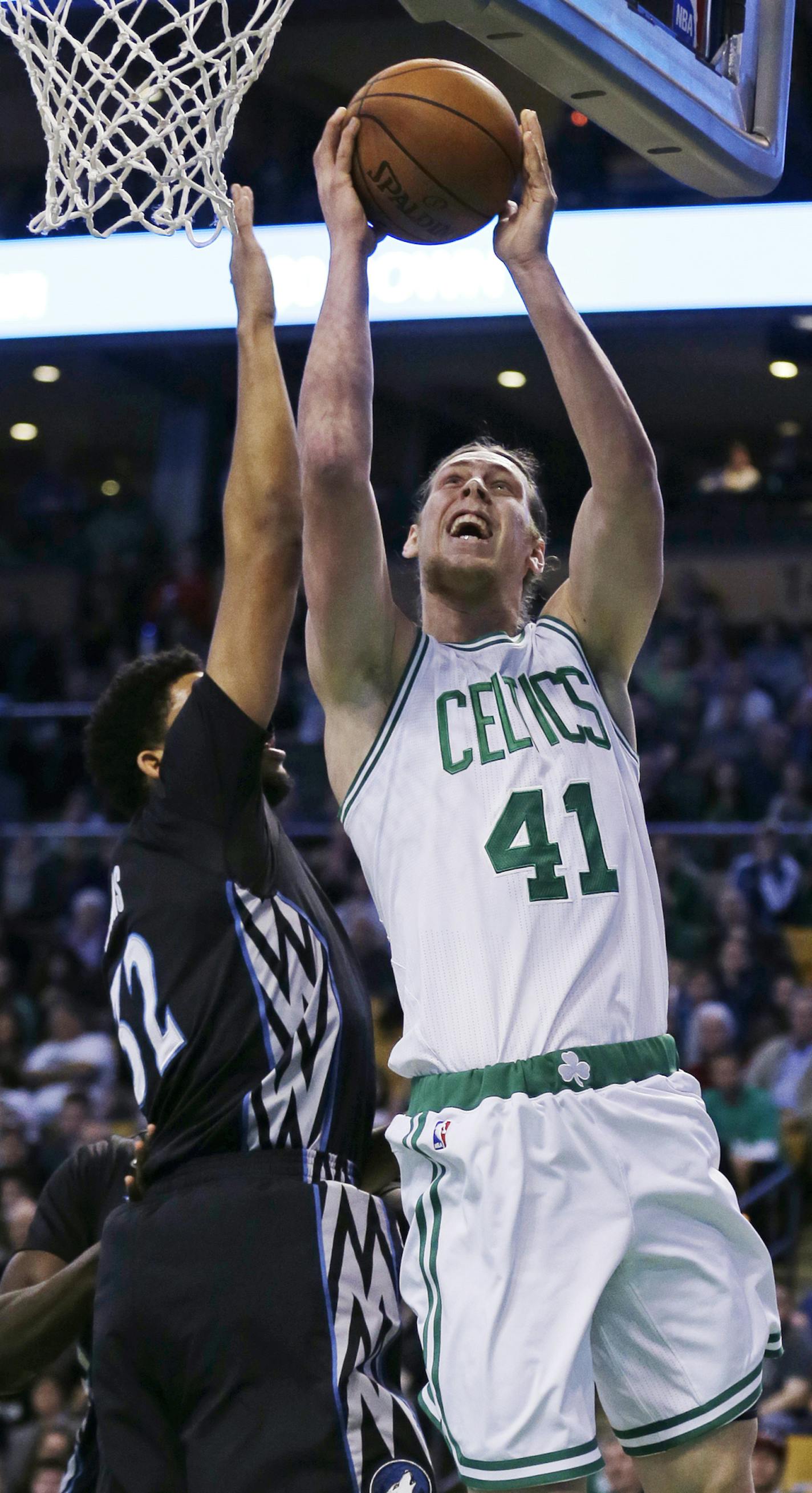 Boston Celtics center Kelly Olynyk drives to the basket against Minnesota Timberwolves center Karl-Anthony Towns (32) during the first quarter of an NBA basketball game in Boston, Monday, Dec. 21, 2015. Olynyk scored 19 points as the Celtics defeated the Timberwolves 113-99. (AP Photo/Charles Krupa)