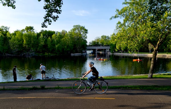 A cyclist passed the Lake of the Isles lagoon and canal on Monday.
