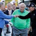 Arnold Palmer, center, watches as Jack Nicklaus, left, and Gary Player touch fists after Palmer hit his ceremonial drive on the first tee during the f