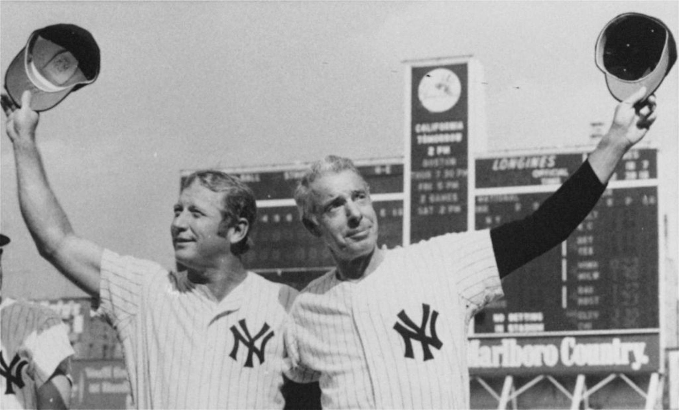 In this July 22, 1972 file photo, New York Yankee greats Mickey Mantle, left, and Joe DiMaggio, doff their caps to the crowd at Yankee Stadium as they appeared for an old timers game between games of a doubleheader between the Yankees and the California Angels.