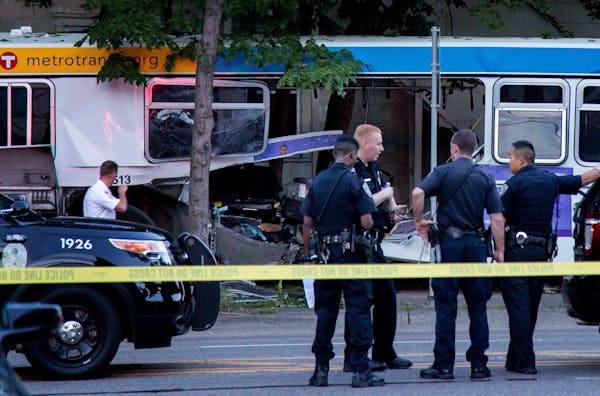 Police stand near the bus that a car collided with during a fatal crash in St. Paul on July 21, 2017.