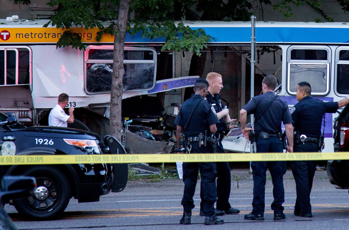 Police stand near the bus that a car collided with during a fatal crash in St. Paul on July 21, 2017.