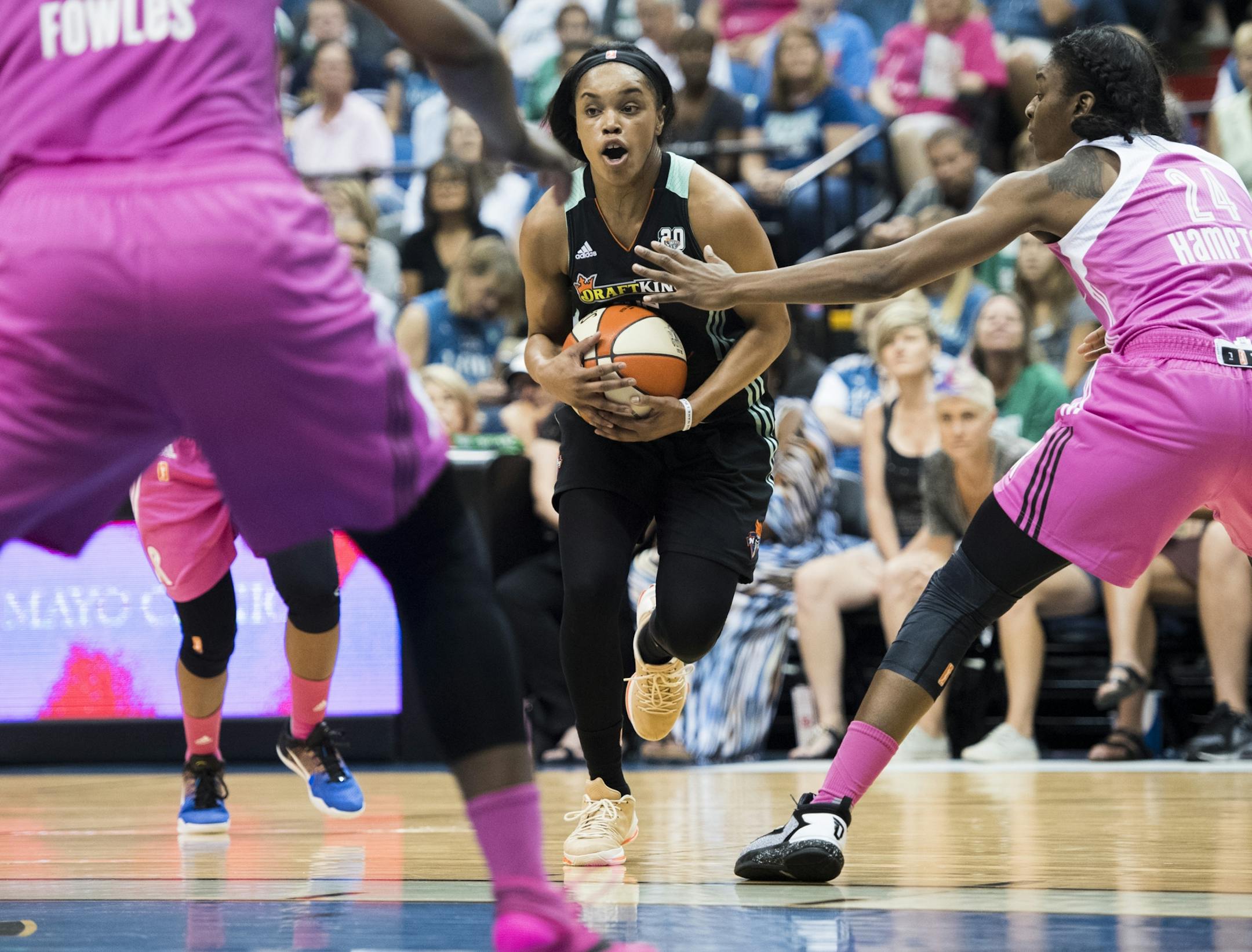 New York Liberty guard Brittany Boyd (15) drove towards the basket and by Minnesota Lynx forward Keisha Hampton (24) and center Sylvia Fowles (34).