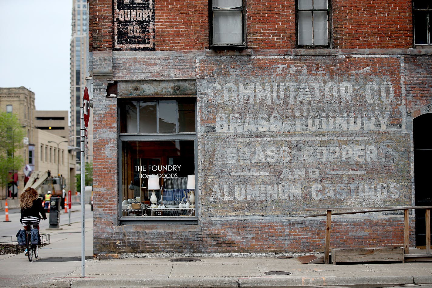 A cyclist made her way near an old Commutator sign located on the side of a business in Minneapolis, MN. ] (ELIZABETH FLORES/STAR TRIBUNE) ELIZABETH FLORES &#x2022; eflores@startribune.com