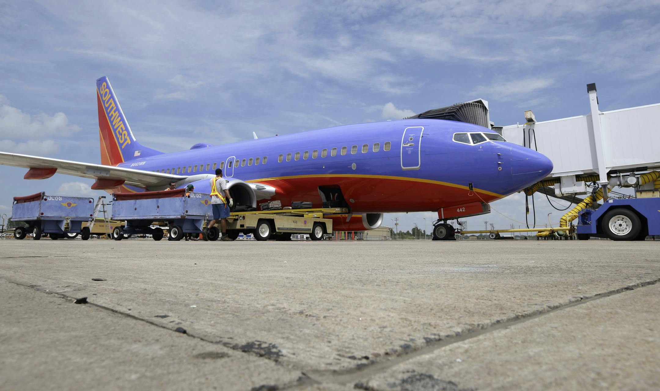 In this June 19, 2014 photo, a Southwest Airlines Boeing 737 is serviced at Bill and Hillary Clinton National Airport in Little Rock, Ark. The Federal Aviation Administration on Monday, July 28, 2014 is proposing a $12 million civil fine against Southwest Airlines for failing to comply in three separate cases with safety regulations related to repairs on Boeing 737 jetliners. (AP Photo/Danny Johnston)