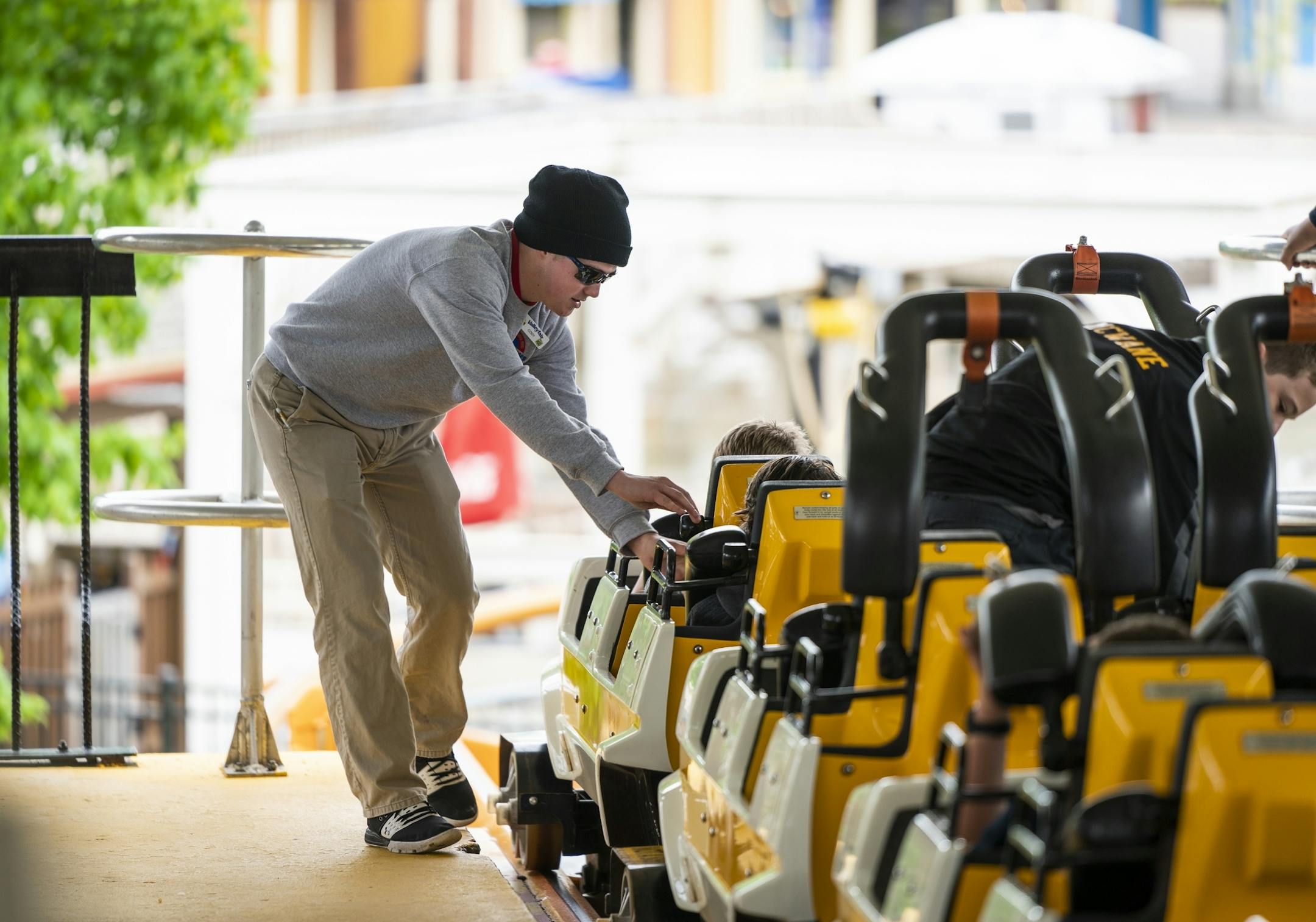 Cody White, 21, a ride operator at ValleyFair, makes sure riders are secured in the Corkscrew roller coaster.