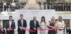 FILE &#xf3; Donald Trump, center, cuts the ribbon with his wife and children during the opening ceremony at Trump International Hotel in Washington, O