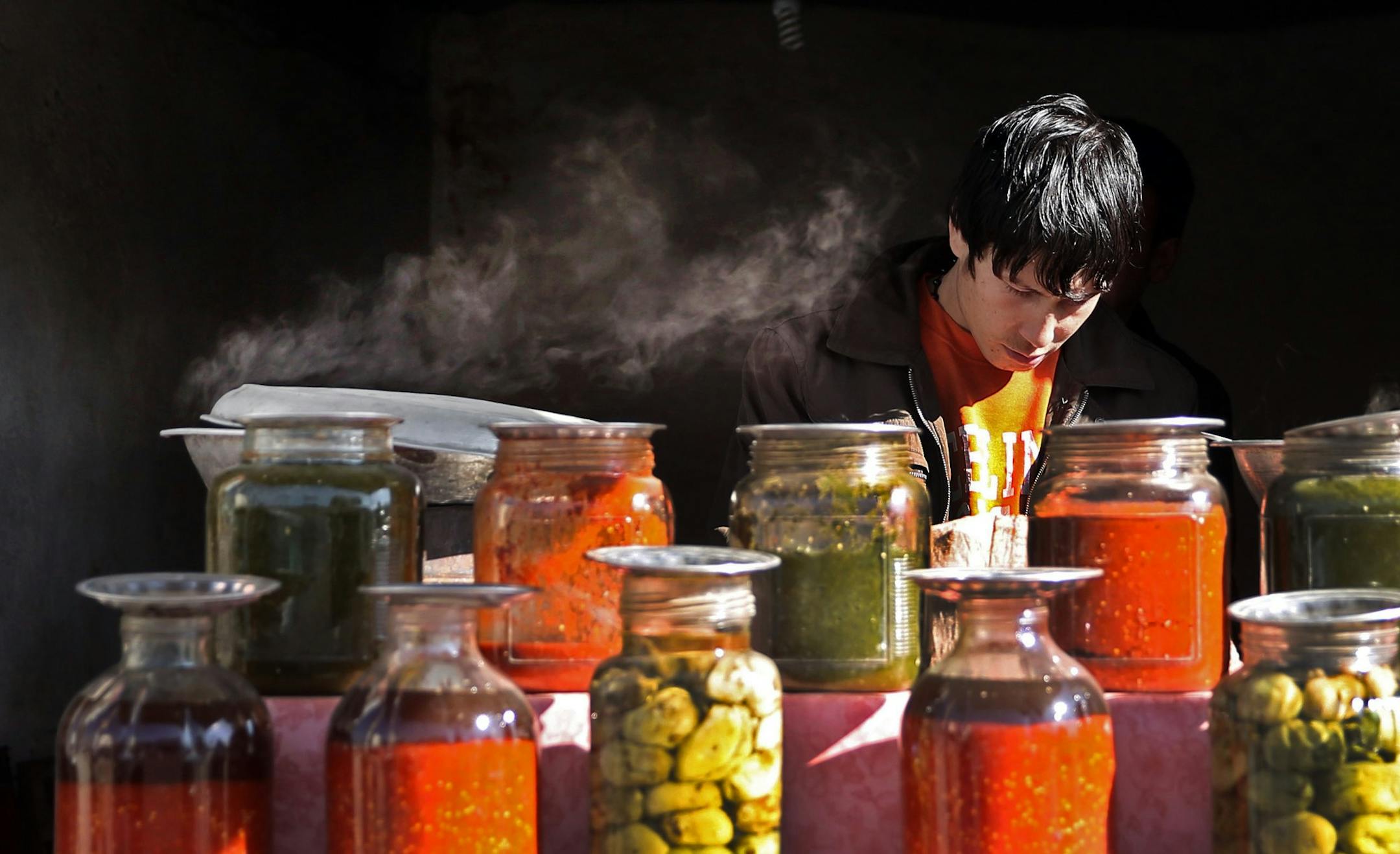 FILE - In this Tuesday, Dec. 15, 2015 photo, an Afghan man sells traditional sauces and pickles on a street in Kabul, Afghanistan. (AP Photo/Massoud Hossaini, File) ORG XMIT: XMS104