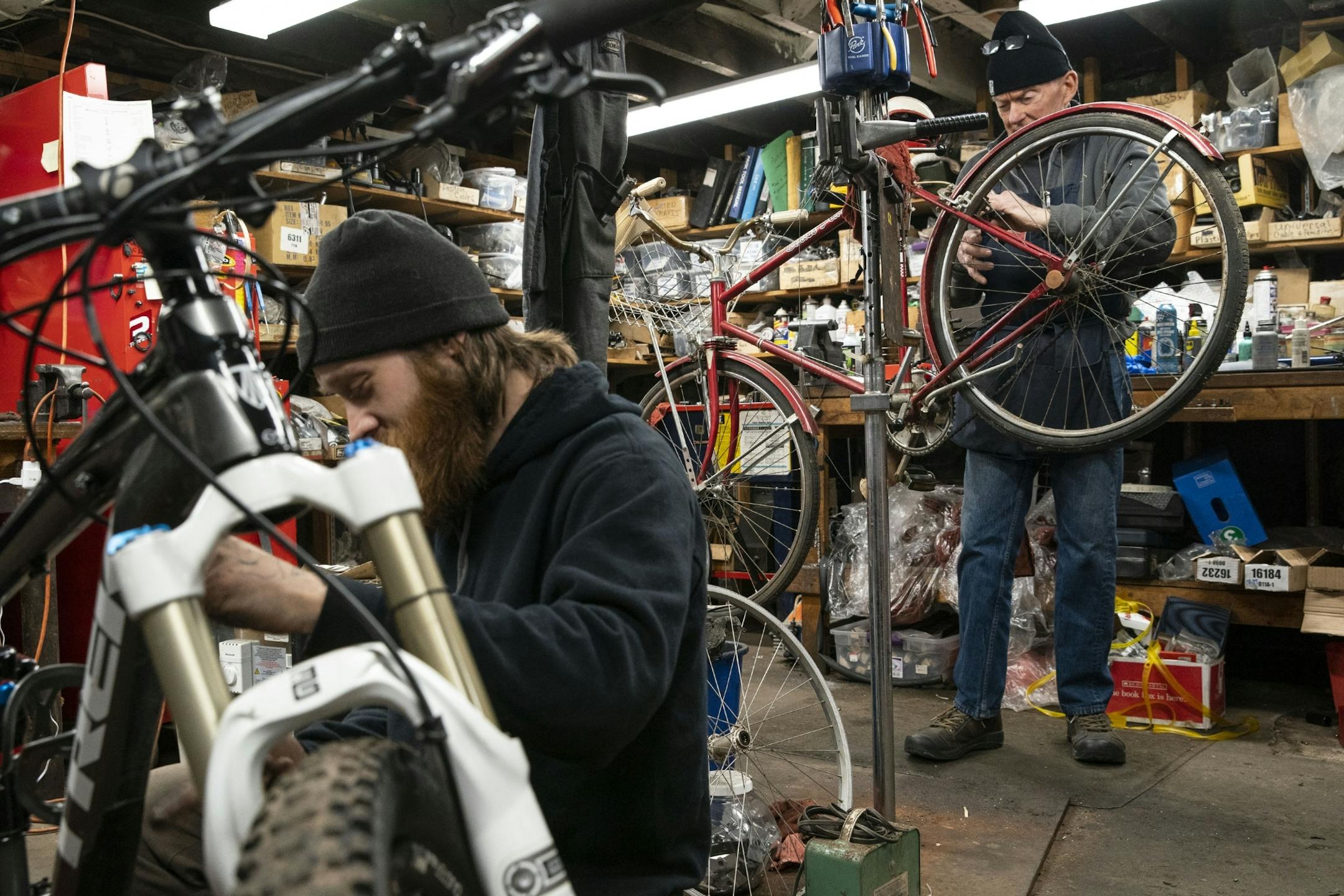 (Left) Cassidy Olson, a mechanic at Twin Ports Cyclery, and Denis Sauve, the co-owner of the shop, worked on repairing bikes on Friday afternoon while maintaining a distance from one another.