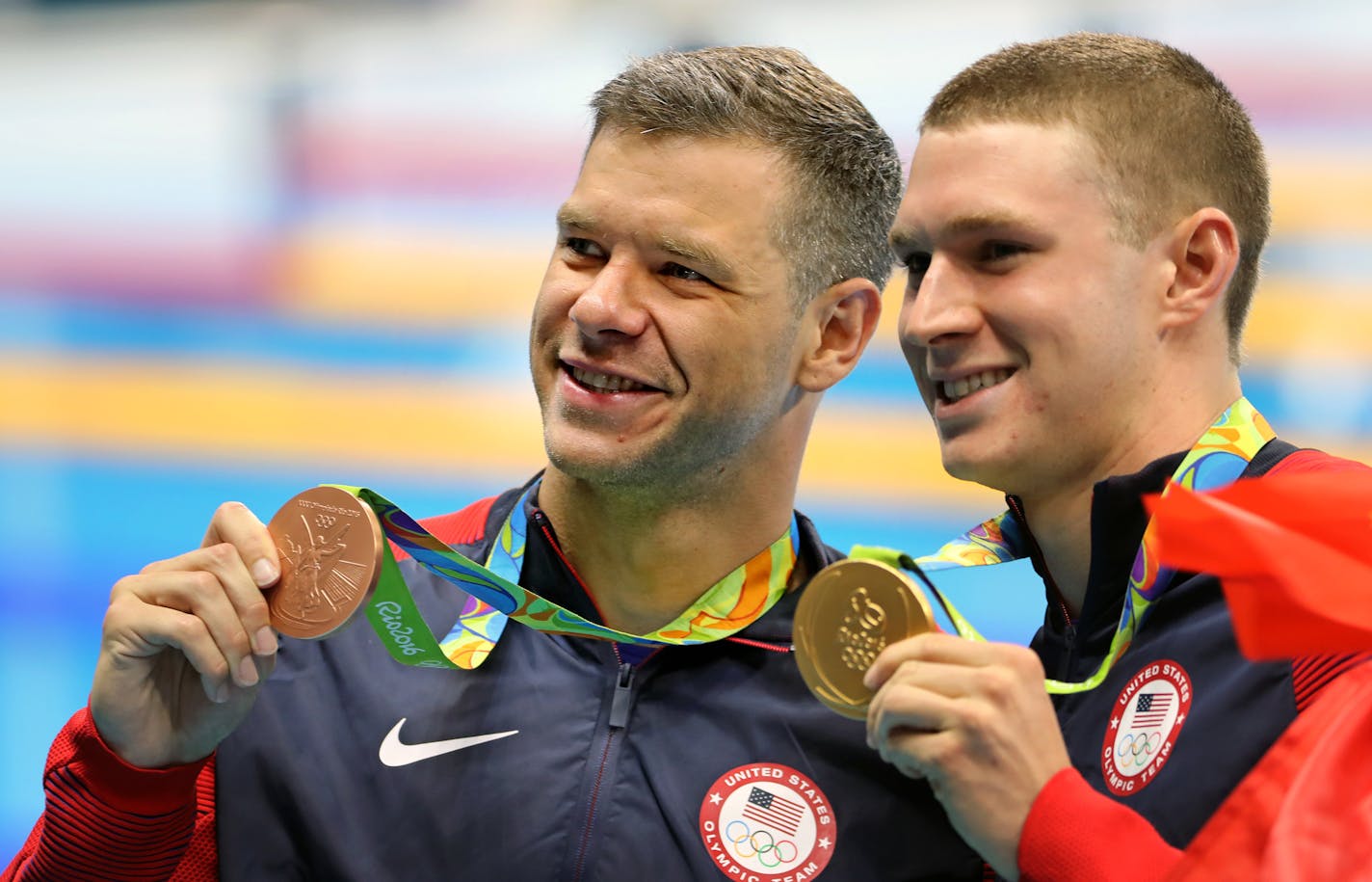 Minnesota's David Plummer, left, and teammate Ryan Murphy hold up their bronze and gold medals after the 100-meter backstroke final on Monday in the Rio Olympics.