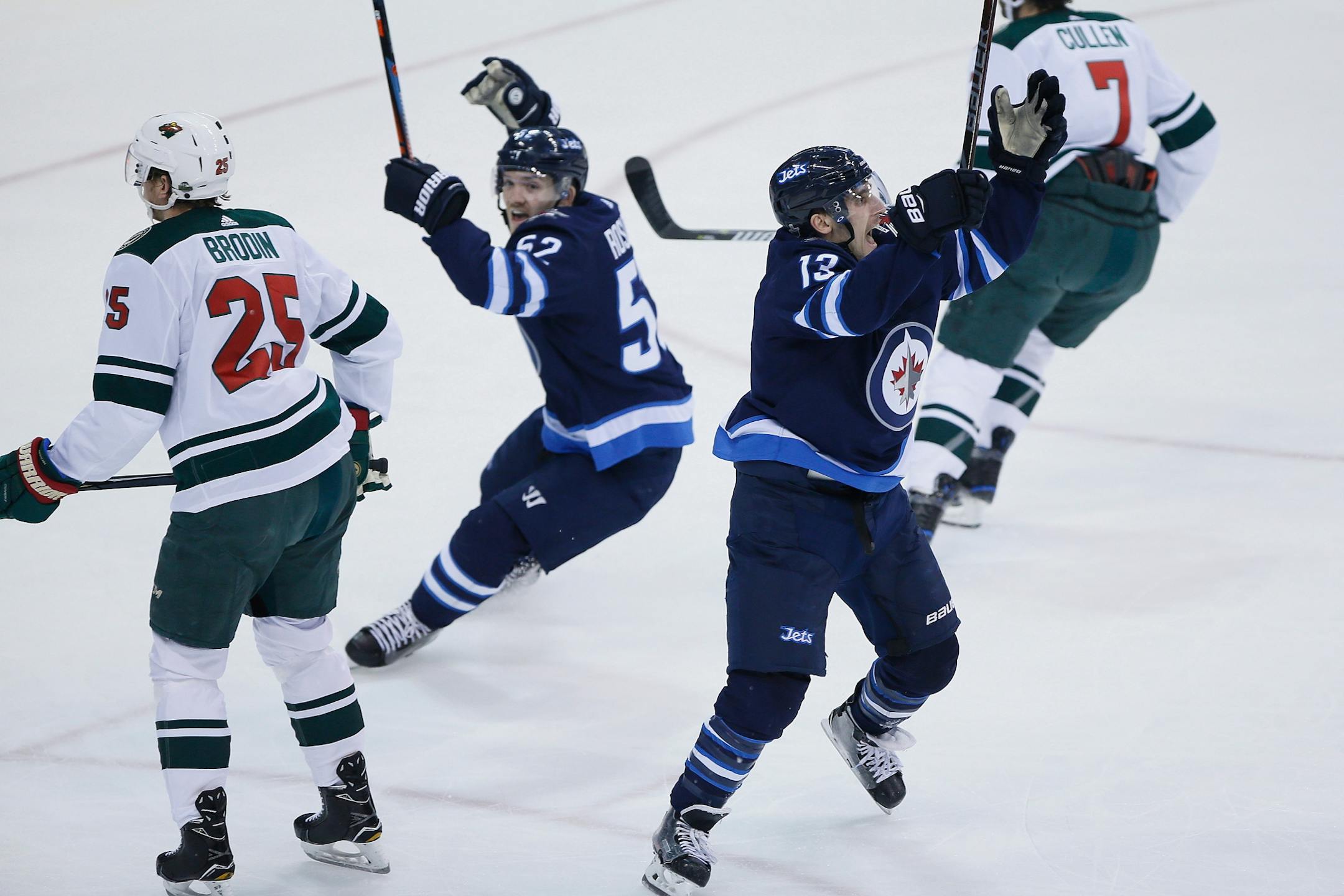 Winnipeg Jets' Jack Roslovic (52) and Brandon Tanev (13) celebrate Tanev's goal, as Minnesota Wild's Jonas Brodin (25) and Matt Cullen (7) turn away during the first period in Game 5 of an NHL hockey first-round playoff series in Winnipeg, Manitoba, Friday, April 20, 2018.