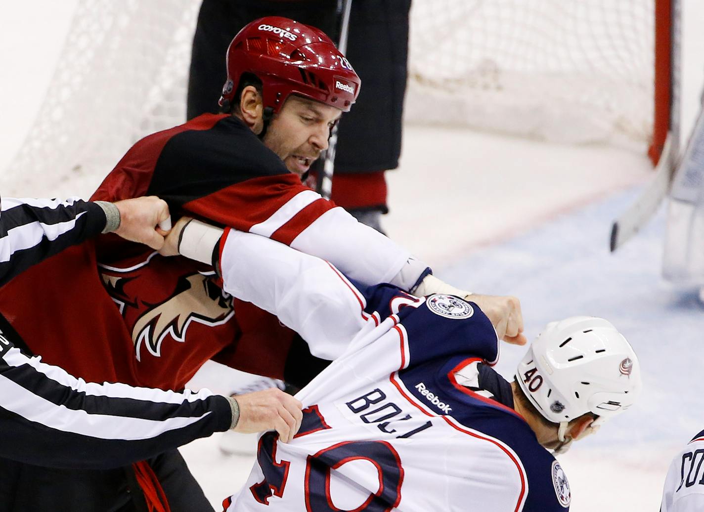 Arizona Coyotes' John Scott, left, punches Columbus Blue Jackets' Jared Boll (40) during a fight in the second period of an NHL hockey game Thursday, Dec. 17, 2015, in Glendale, Ariz. (AP Photo/Ross D. Franklin)