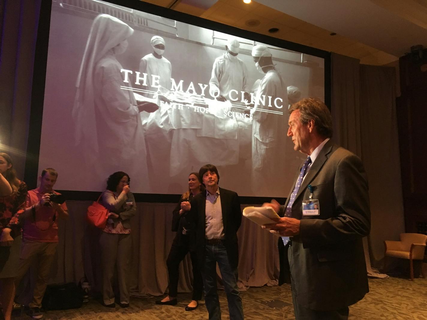 Ken Burns (center) was introduced by Mayo Clinic CEO Dr. John Noseworthy (right) Wednesday in Rochester. Burns gave Mayo staff a sneak preview of a documentary about the clinic that PBS will broadcast in the fall.