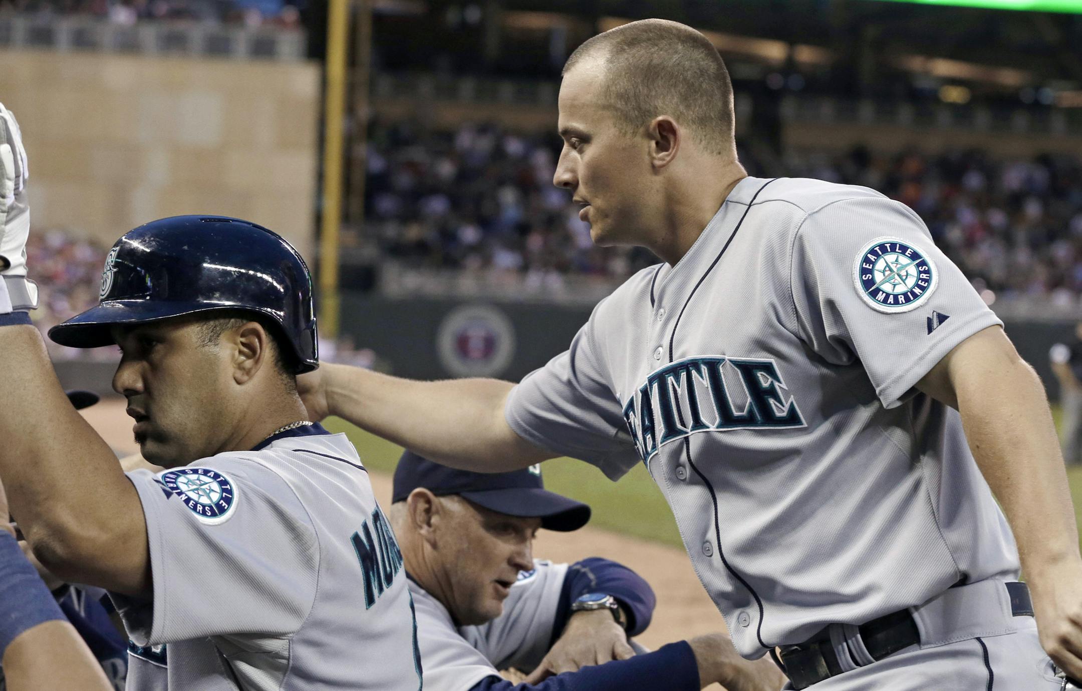 Seattle Mariners' Kendrys Morales, left, is followed by Kyle Seager to the dugout after Morales' two-run home run off Minnesota Twins' Mike Pelfrey drove him in in the sixth inning of a baseball game, Friday, May 31, 2013 in Minneapolis. (AP Photo/Jim Mone)