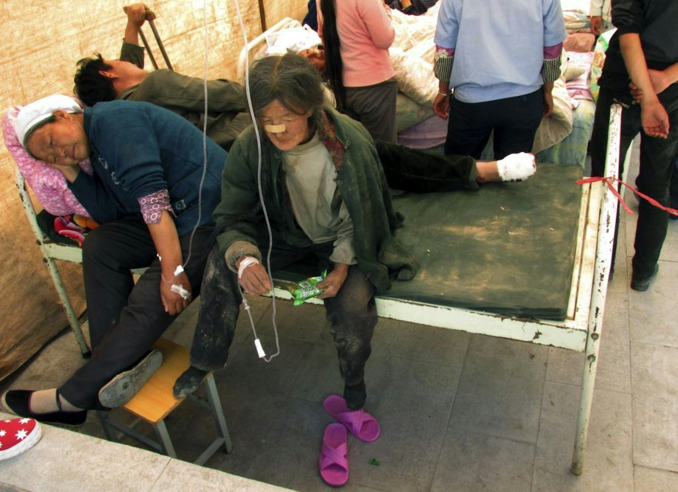 Residents receive medical treatment on the grounds of a hospital after an earthquake hit Minxian county in northwest China's Gansu province Monday July 22, 2013.