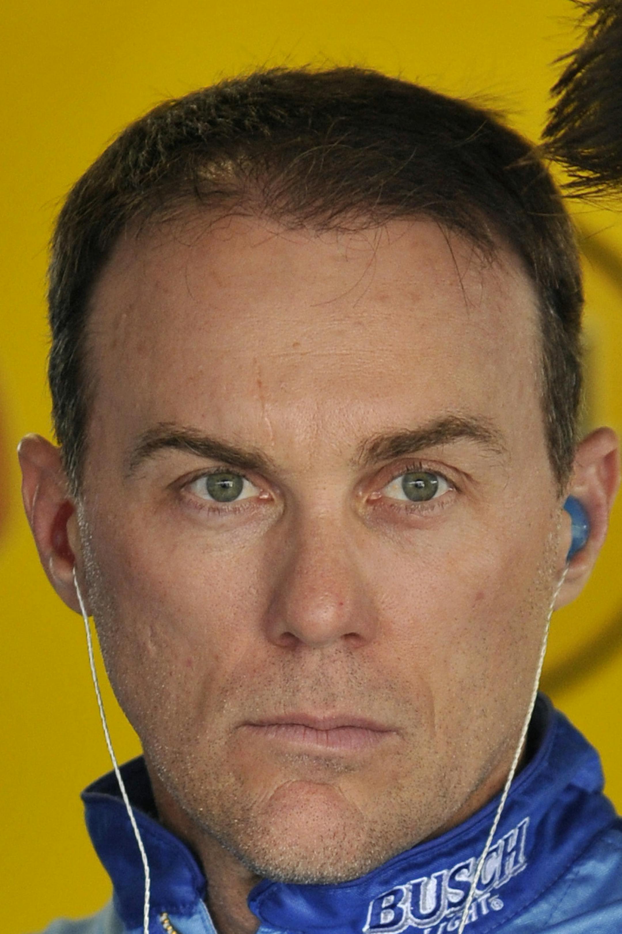 Driver Kevin Harvick, left, listens to his crew chief Rodney Childers as he waits for the beginning of a practice session for this weekend's NASCAR Cup Series auto race at Kansas Speedway Friday, May 11, 2018, in Kansas City, Kan. (AP Photo/Ed Zurga)