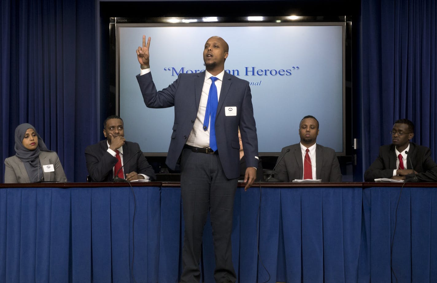 Abdi Phenomenal, center, joined by, seated from left, Hodan Hassan, Associate Vice President, Program Funding and Prospect Development at Save the Children US; Minneapolis City Council Member Abdi Warsame; Mohamed Farah, Executive Director of Ka Joog, and Mohamed Jama, holds up a peace sign and performs &#x201c;More Than Heroes&#x201d; during the Minneapolis St. Paul, Pilot Program presentation, at the White House Summit on Countering Violent Extremism, Wednesday, Feb. 18, 2015, in the South Cou