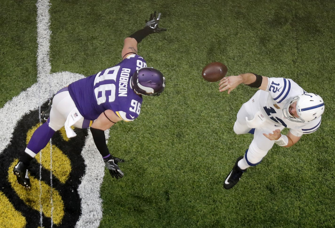 Colts quarterback Andrew Luck (12) attempted a pass while under pressure form Brian Robison (96) in the first quarter.