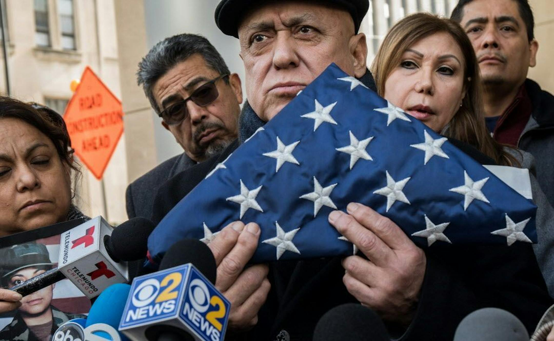 Miguel Perez Sr., center, and his wife, Esperanza, arrive at a hearing for their son, Army veteran Miguel Perez Jr., on Feb. 6, 2017. Perez holds the flag his son gave him after his return from Afghanistan.