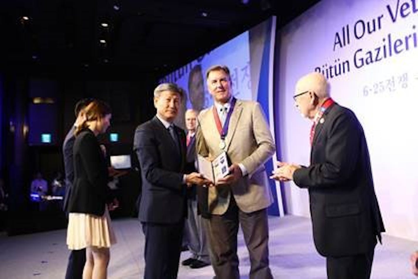 Randy Gilbert receiving a medal on behalf of his dad.