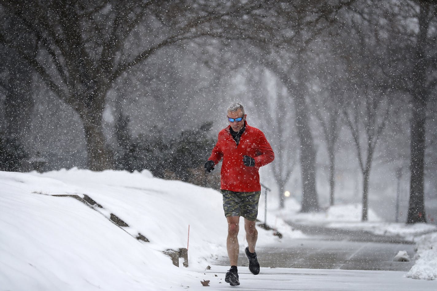 Mike Wickman of Minneapolis, who works in St. Paul, goes for a lunch break run in the snow on Summit Avenue in St. Paul.