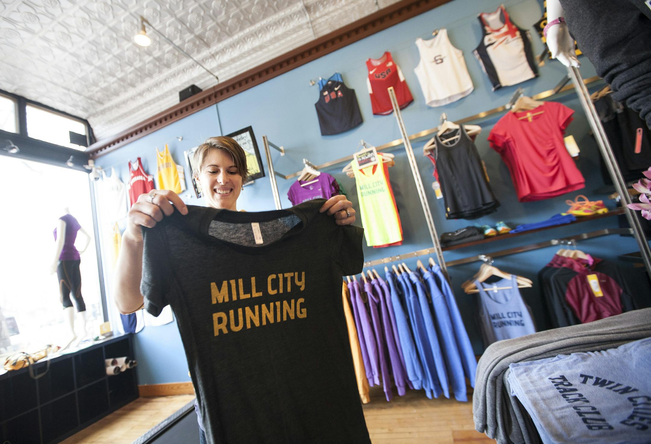 Co-owner Bekah Metzdorff folds tees at Mill City Running in Minneapolis May 3, 2014. (Courtney Perry/Special to the Star Tribune)