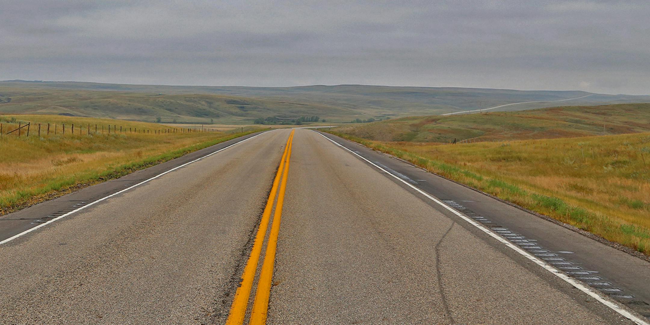 Two lane blacktop: U.S. Highway 14 in western South Dakota stretched to the horizon and beyond.