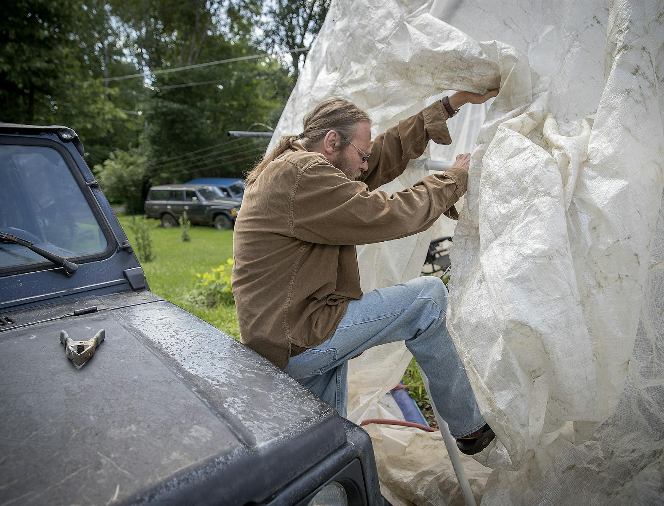 Mike Allen made his way into his makeshift greenhouse that holds a swimming pool for his grandkids.