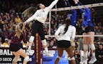 A hit by Minnesota outside hitter Alexis Hart (19) was blocked by Creighton setter Madelyn Cole (18) and middle blocker Megan Ballenger (19) in the se