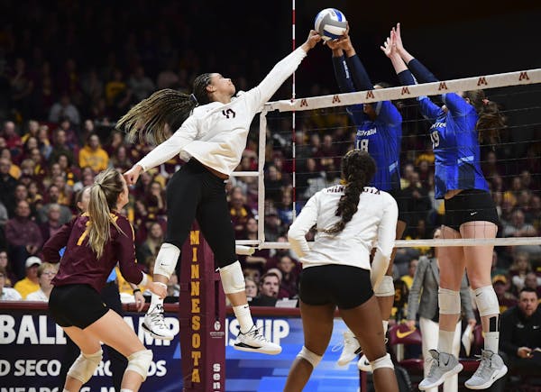 A hit by Minnesota outside hitter Alexis Hart (19) was blocked by Creighton setter Madelyn Cole (18) and middle blocker Megan Ballenger (19) in the se