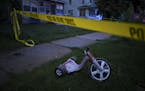 A child's tricycle inside the police tape at the scene of Friday night's shooting in north Minneapolis, in which multiple people were reported shot. ]