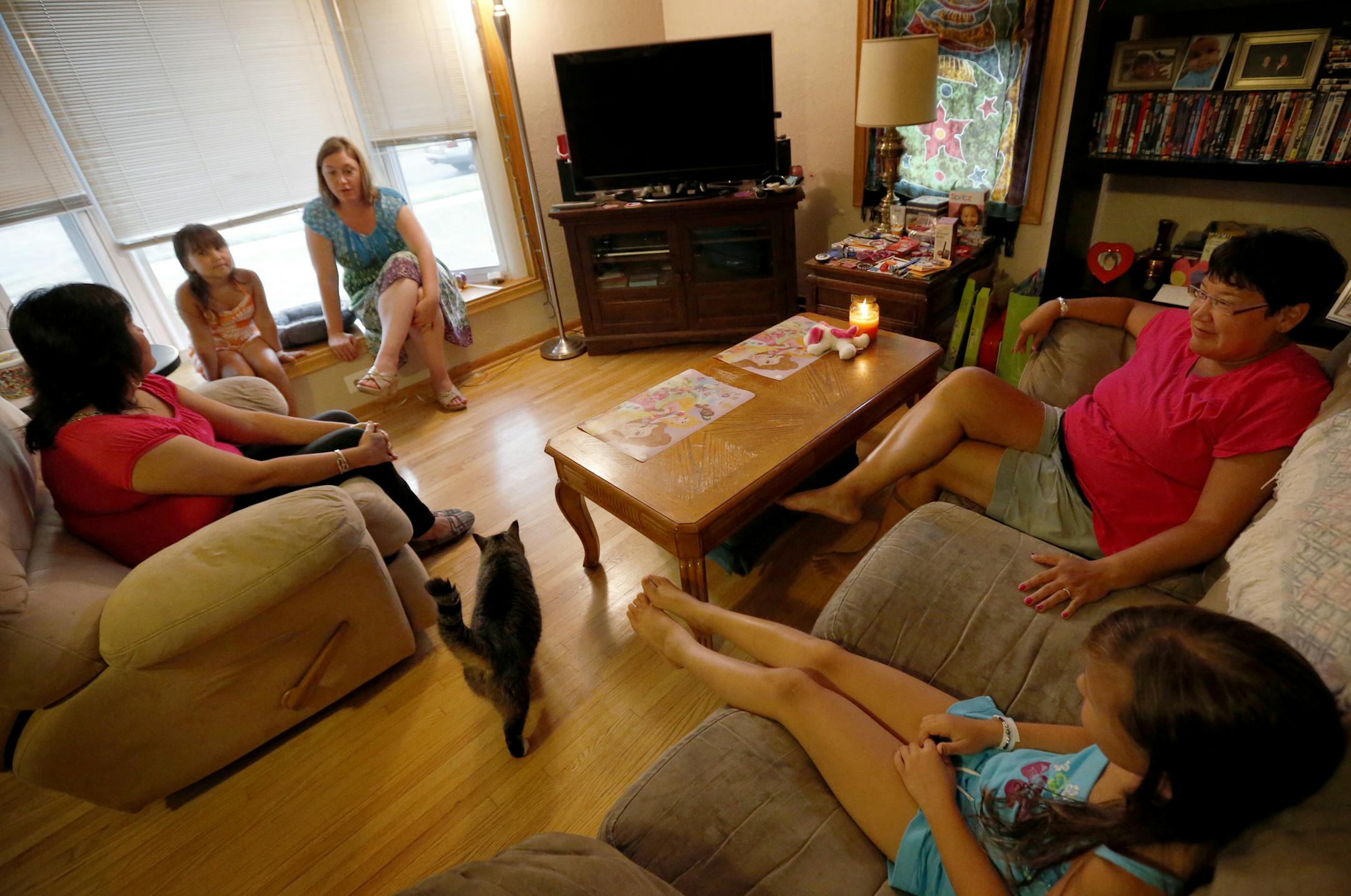 Teacher Gina Hass (middle in blue) and TA Miriam Foote (left) met with the Coyne family whose daughter will be attending Hass' kindergarten class. ] CARLOS GONZALEZ cgonzalez@startribune.com August 21, 2013, St. Paul, Minn., The start of the new school year was weeks away, but St. Paul teacher Gina Hass was already meeting with East Side parents, not at school, but in their homes. Hass, who begins teaching kindergarten this fall at St. Paul's American Indian Magnet School, is part of a parent-te