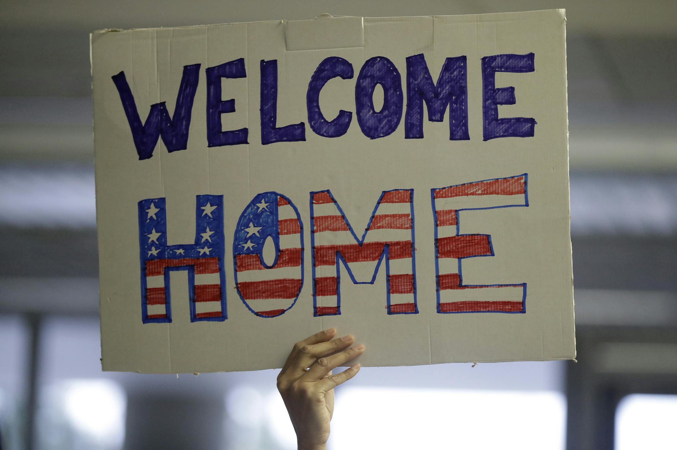 A supporter holds a sign for U.S. Army interpreter Qismat Amin, who would later arrive from Afghanistan, at San Francisco International Airport Wednesday, Feb. 8, 2017, in San Francisco. Army Capt. Matthew Ball welcomed his former translator Amin to the United States after buying him a plane ticket to ensure his quick arrival amid concerns the Trump administration might try to expand its travel ban to Afghanistan. (AP Photo/Marcio Jose Sanchez) ORG XMIT: CAMS109