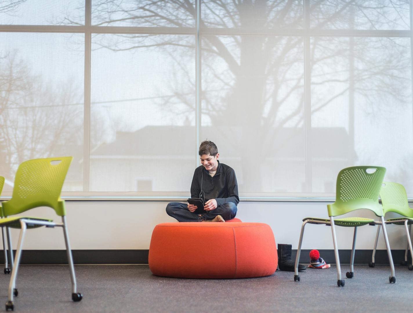 Casper York, age of 13, watches his iPad Saturday afternoon. Casper lives across the street and expressed his excitement for the new facility saying that he will be there always] Elizabeth Brumley special to the Star Tribune * The revamped Palace Recreation Center officially opens Saturday.