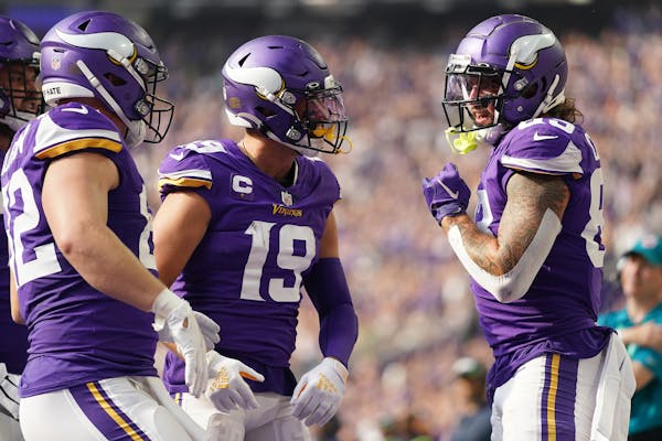 Vikings tight ends Ben Ellefson, left, and Tyler Conklin, right, celebrate Conklin’s touchdown against Seattle with Adam Thielen. 