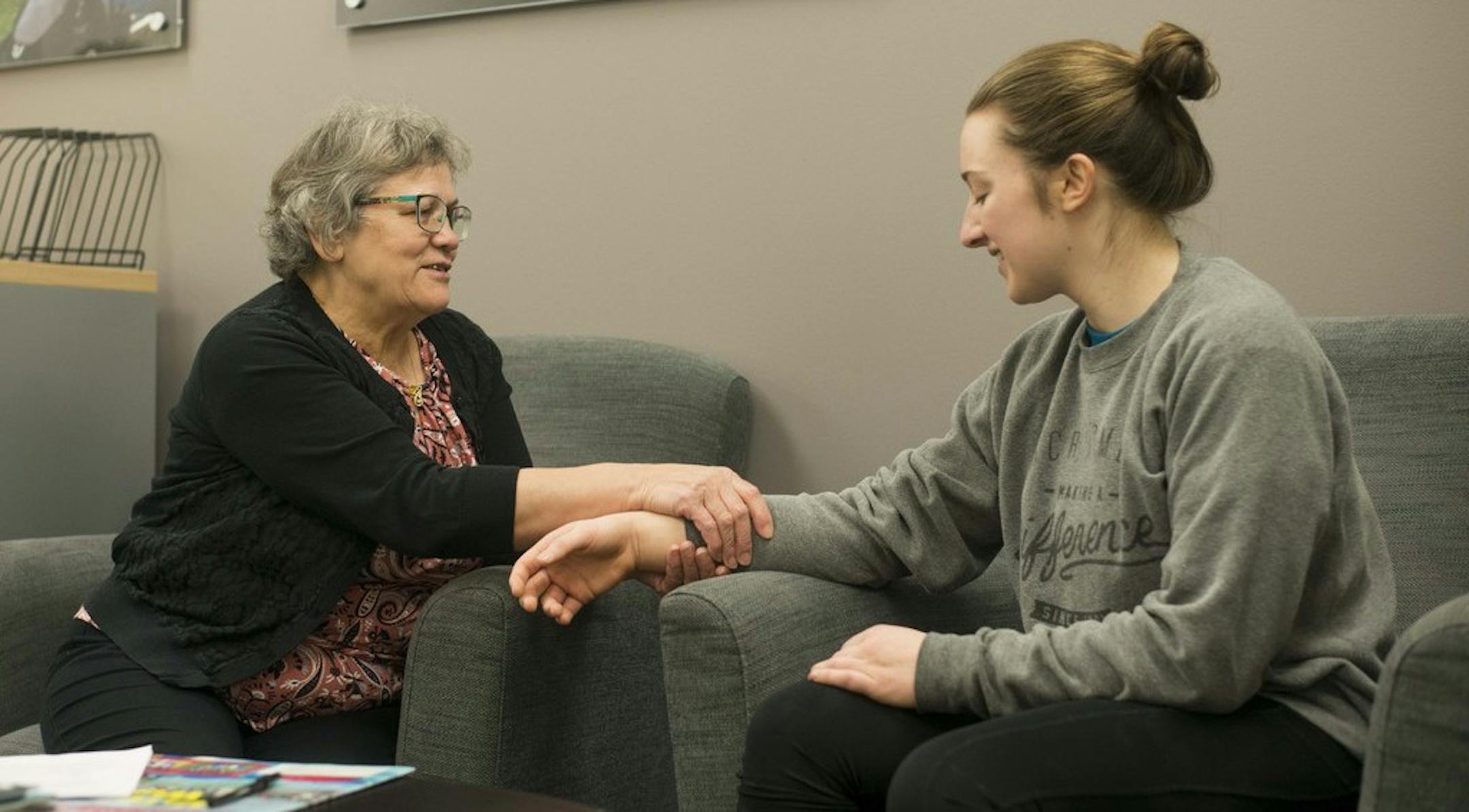 ADVANCE FOR PUBLICATION ON SATURDAY, NOV. 23, AND THEREAFTER - In this Monday, Nov. 11, 2019, photo, massage therapist Ioana "Coca" Vladislav gives an impromptu hand massage to student Emily Clarke at the University Recreation and Wellness Center, in Minneapolis. Vladislav is known as "Grandma Coca" and has been working at the U for 20 years. (Nur B. Adam/The Minnesota Daily via AP)