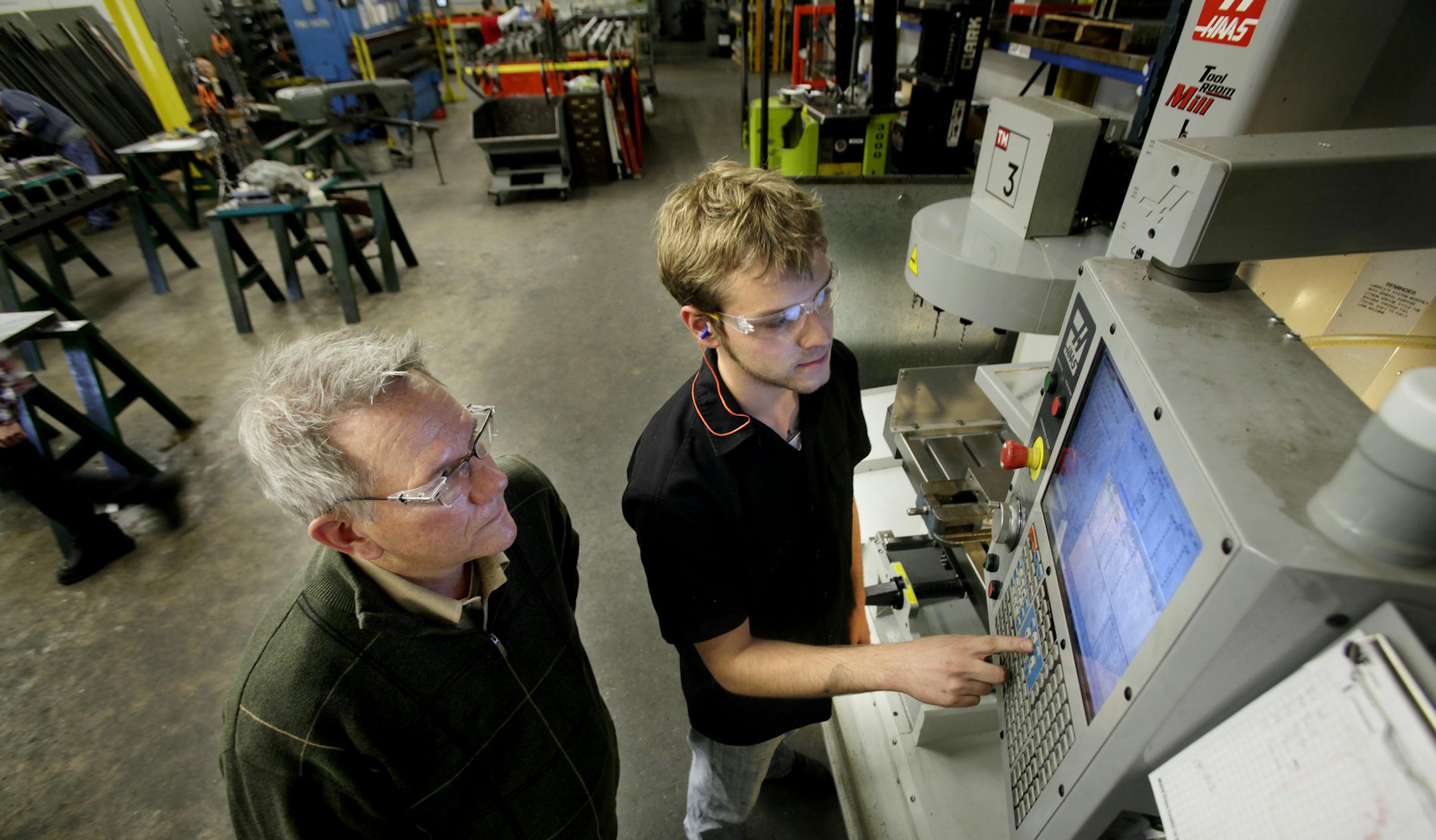 Dunwoody intern, Joe Brudzinski, (right), talks to Erick Ajax, co-owner of E.J. Ajax & Sons Inc., about a part that he was working on at the Fridley, MN plant on March 25, 2013. ] JOELKOYAMA&#x201a;&#xc4;&#xa2;joel koyama@startribune.com Ajax at EJ Ajax & Sons in Fridley is hosting a Dunwoody College of Technology Da. They are celebraing the graduation of several employee/ apprentices into full journeyman status. This company is a metal stamper that trains folksin high tech manufacturing. It par