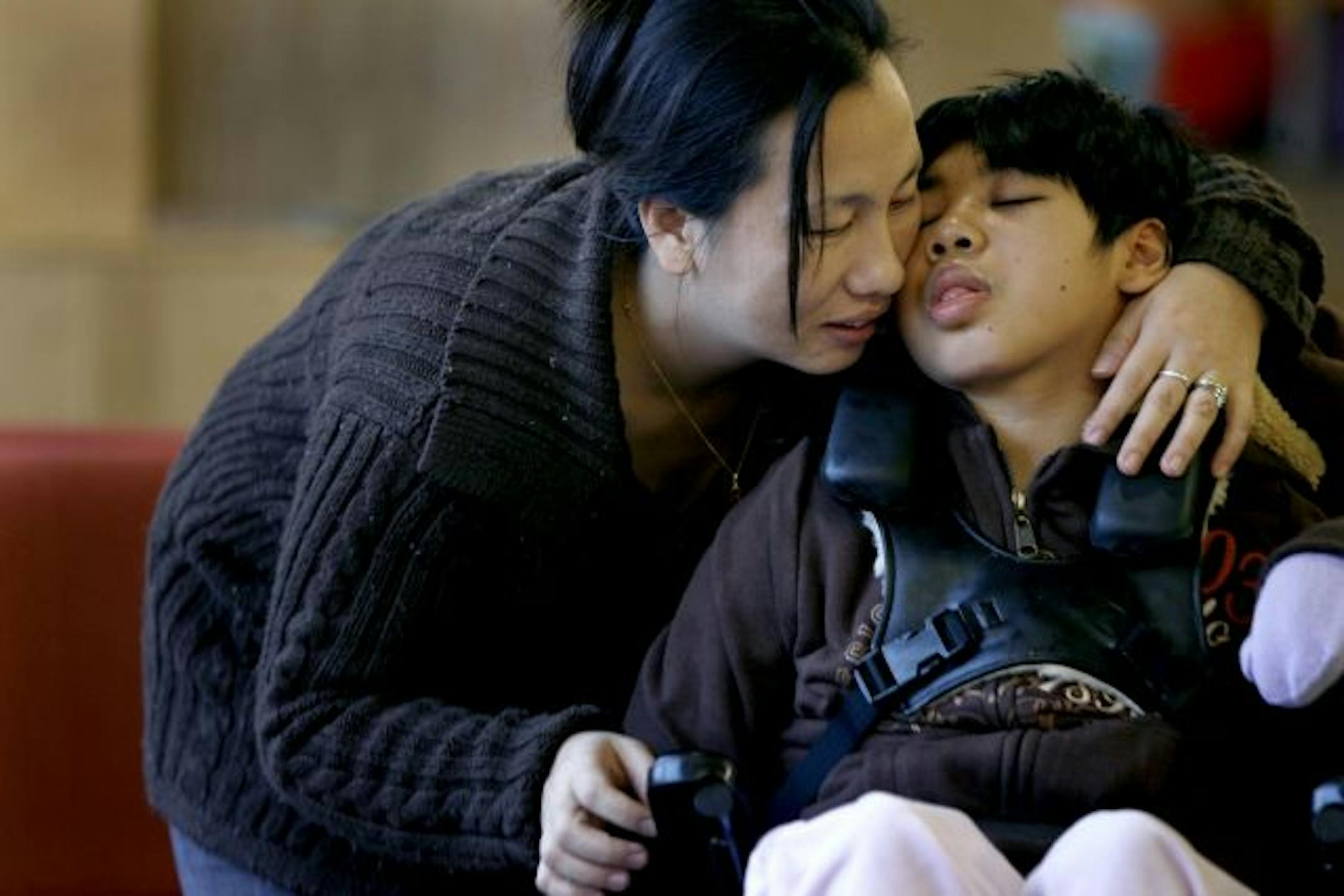 Choua Yang, 32, gave daughter, Panhia, 8, a hug before a meeting with her social worker at Gillette Children's Hospital. Yang gave back a misdirected $8,135.26 check even though she has four kids and no job.
