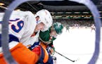 Brock Nelson of the Islanders and Jonas Brodin of the Wild fought for the puck in the second period of the Wild’s 5-2 victory Sunday at Xcel Energy 