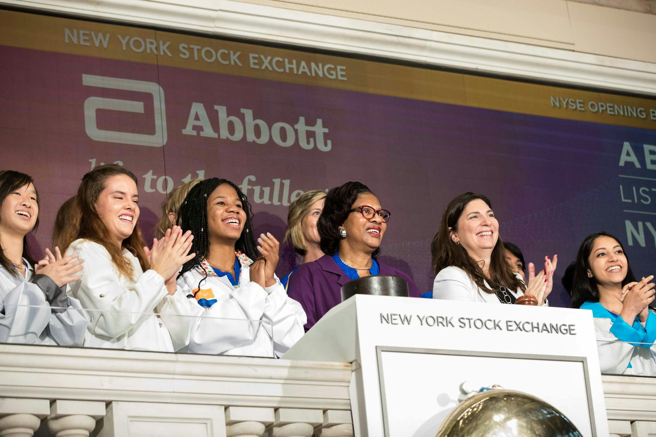 Corlis Murray, Abbott Laboratories' top engineer (center) rings the New York Stock Exchange bell along with Abbott engineering interns including Roseville High School junior Jomi Babatunde-Omoya (to the right of Murray). The interns are wearing lab coats that they redesigned for modern uses and sensibilities. .