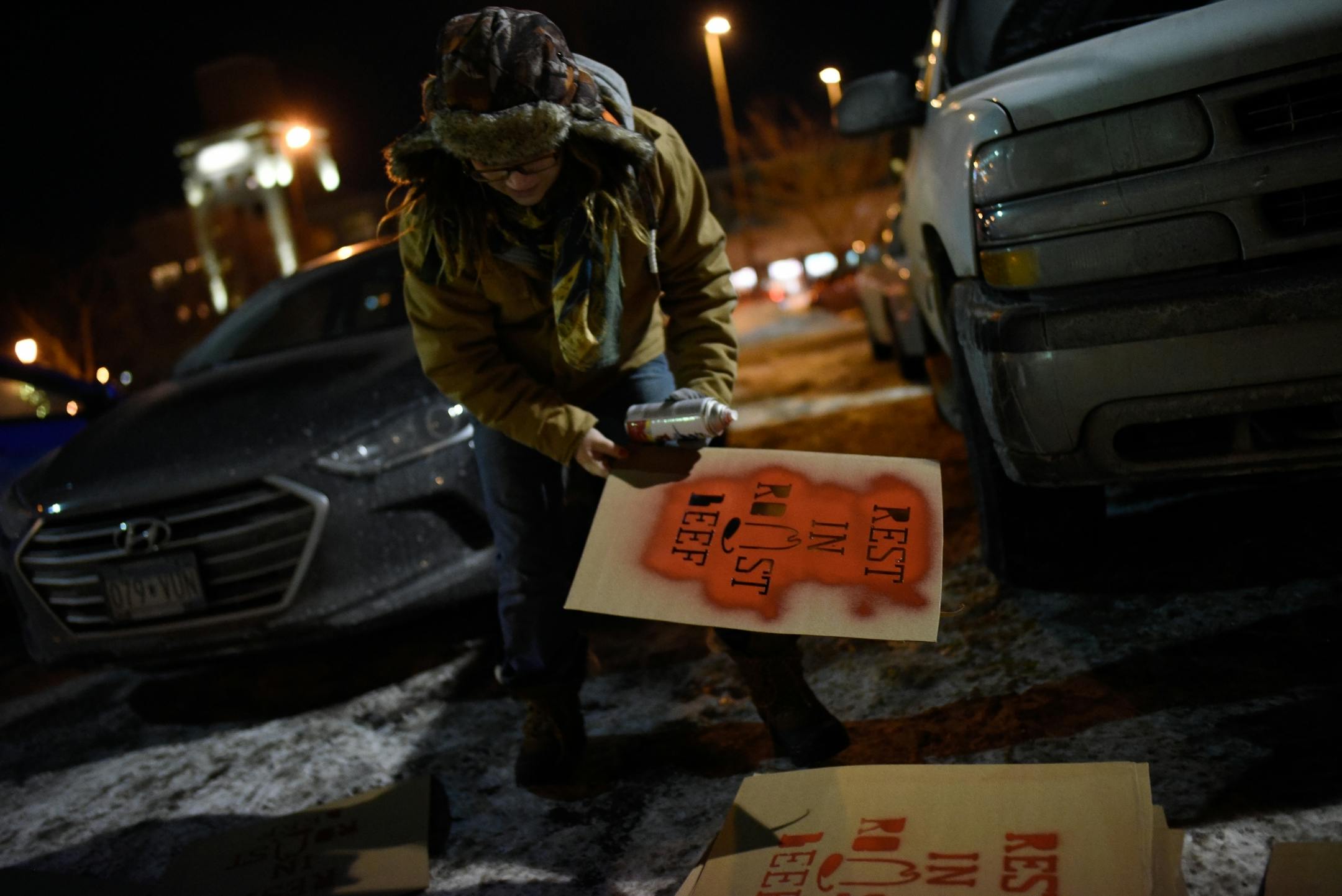 Ashley LeMay, of St. Paul, spray painted "Rest in Roast Beef" signs that she would place up against the now-closed Uptown Arby's before the start of Friday night's candlelight vigil.