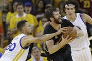 Cleveland Cavaliers forward Kevin Love, center, is defended by Golden State Warriors guard Stephen Curry (30) and forward Anderson Varejao during the 