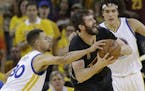 Cleveland Cavaliers forward Kevin Love, center, is defended by Golden State Warriors guard Stephen Curry (30) and forward Anderson Varejao during the 