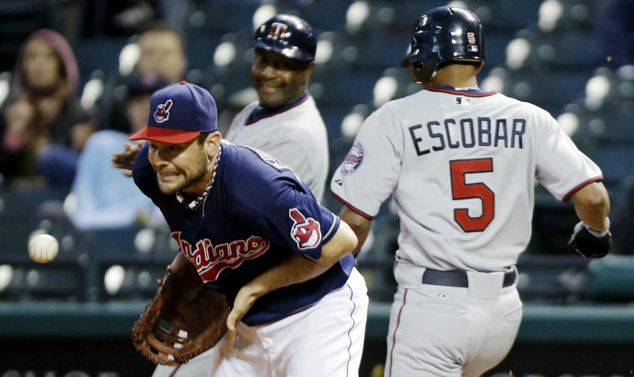 Minnesota's' Eduardo Escobar reaches first on an infield single as Cleveland first baseman Casey Kotchman takes the throw in the second inning.