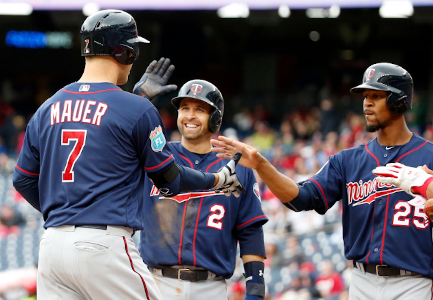 Minnesota Twins' Joe Mauer (7) celebrates knocking in Brian Dozier (2) and Byron Buxton (25) with a three-run home run during the third inning of an exhibition baseball game against the Washington Nationals at Nationals Park, Saturday, April 2, 2016, in Washington. (AP Photo/Alex Brandon)