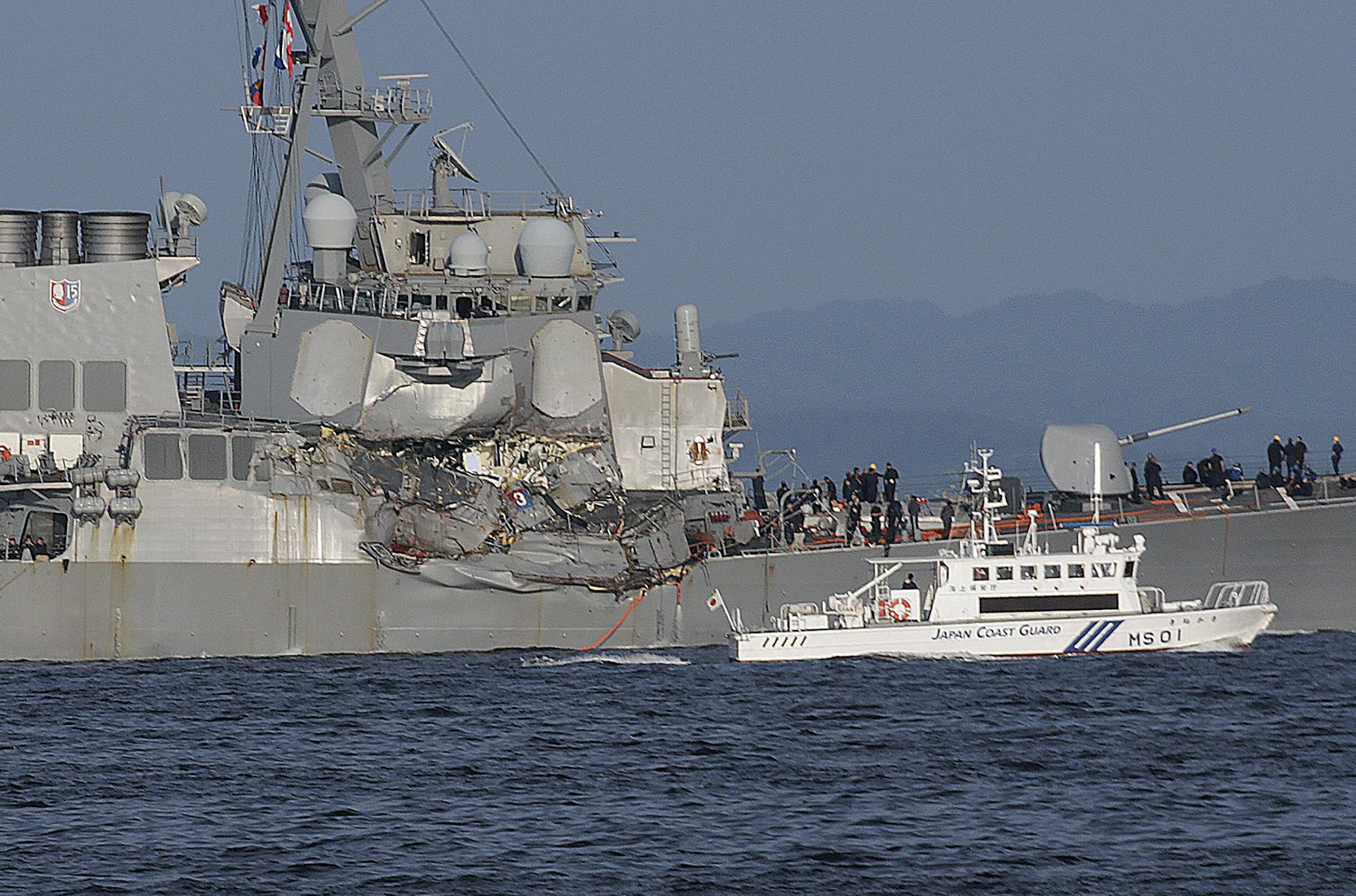 A Japan Coast Guard ship, foreground, navigates the damaged USS Fitzgerald near the U.S. Naval base in Yokosuka, southwest of Tokyo, after the U.S. destroyer collided with the Philippine-registered container ship ACX Crystal in the waters off the Izu Peninsula Saturday, June 17, 2017. The USS Fitzgerald was back at its home port in Japan after colliding before dawn Saturday with a container ship four times its size, while the coast guard and Japanese and U.S. military searched for seven sailors
