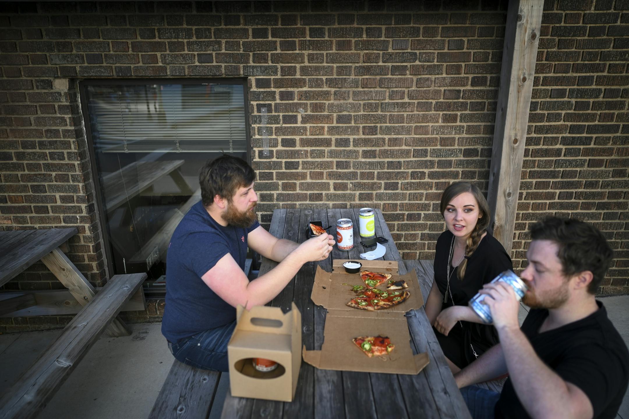 From left, Steven, no last name given, Tiffanie Winders and Verdon Kleimenhagen drank beer and ate pizza outside Black Sheep Wednesday in the North Loop.