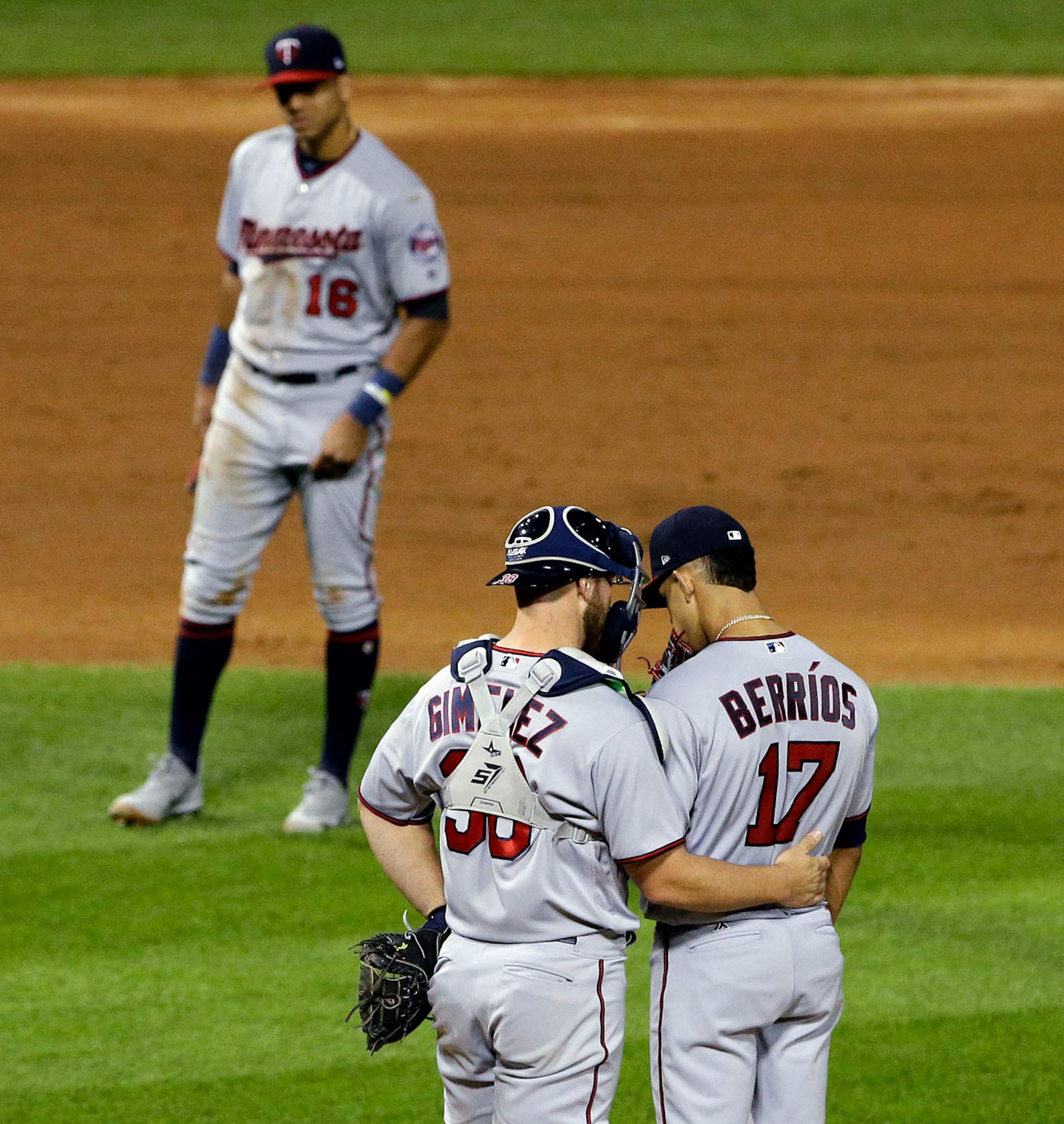 Minnesota Twins catcher Chris Gimenez, left, talks with starting pitcher Jose Berrios as third baseman Ehire Adrianza watches during the fourth inning of a baseball game against the Chicago White Sox, Thursday, Aug. 24, 2017, in Chicago.