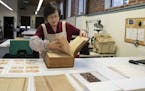 Jungohk (Theresa) Cho, who restored Betsy Ross's family Bible, flips through its pages in the lab at the Conservation Center for Arts and Historic Art